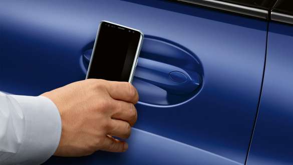 BMW Digital Key BMW 8 Series Coupé G15 LCI Facelift 2022 BMW Digital Key BMW 8 Series Coupé M Portimao Blue metallic G15 LCI Facelift 2022 hand holding smartphone in front of car door