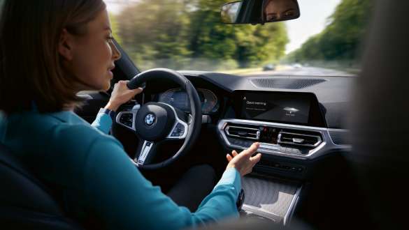 BMW Intelligent Personal Assistant Woman using BMW ConnectedDrive Intelligent Personal Assistant driving in her BMW