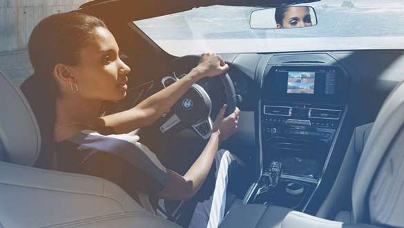 BMW In-Car Experiences Woman relaxes while driving her BMW with the In-Car Experiences