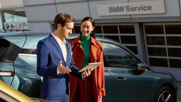 BMW tyres, Man in front of BMW i4 at charging station BMW tyres, Man in front of BMW i4 at charging station