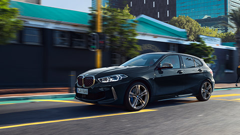 BMW M135i xDrive (F40) three-quarter side view driving in the city BMW M135i xDrive (F40) three-quarter side view driving in the city