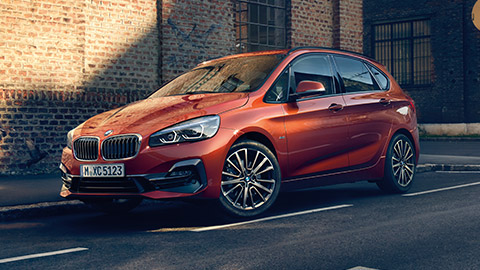 BMW 2 Series Active Tourer F45 three-quarter side view driving on the street BMW 2 Series BMW 2 Series Active Tourer F45 three-quarter side view driving on the street