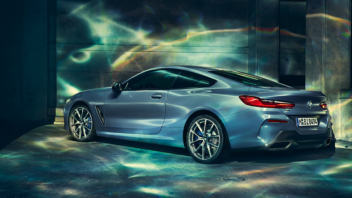BMW 8 Series Coupé, three-quarter rear shot G15. Three-quarter rear shot of the BMW 8 Series Coupé at night in front of an urban setting G15.
