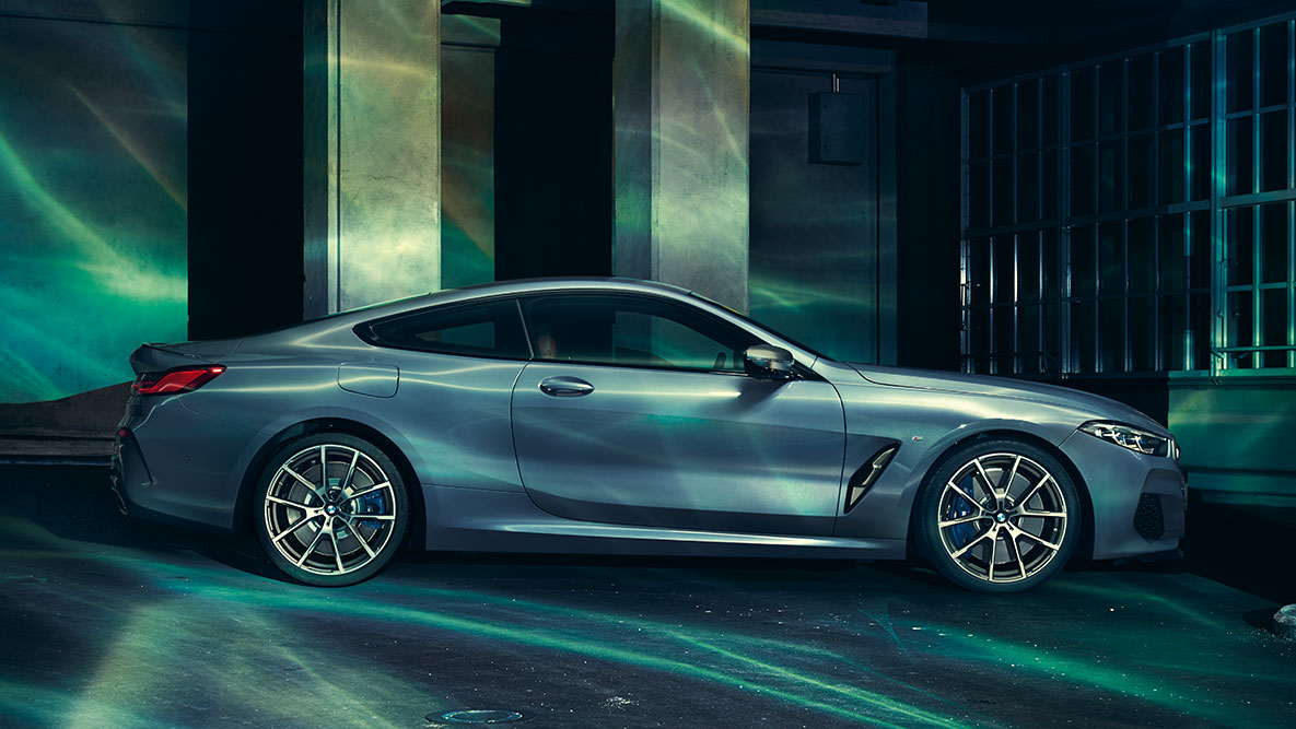 The BMW 8 Series Coupé, side view G15. A still shot of the BMW 8 Series Coupé from the side in an urban setting G15.