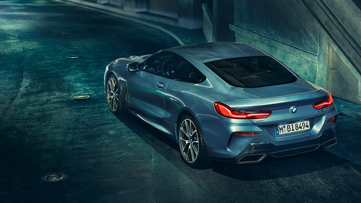 BMW 8 Series Coupé, three-quarter rear shot G15. Three-quarter rear shot of the BMW 8 Series Coupé at night in front of an urban setting G15.