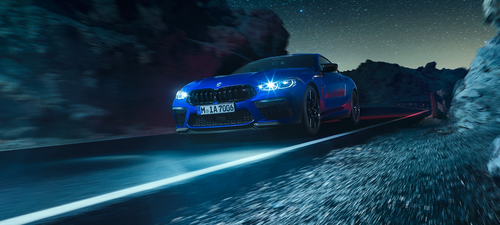 BMW M8 Competition Coupé, three-quarter front view F92. The BMW M8 Competition Coupé in Marina Bay Blue metallic, three-quarter front view, driving at night F92.