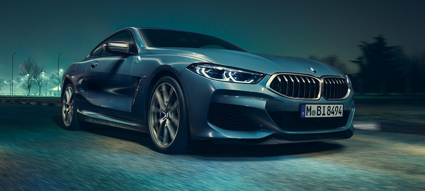 BMW M850i xDrive Coupé, three-quarter front view G15. BMW M850i xDrive Coupé in Barcelona Blue metallic driving, three-quarter front view G15.