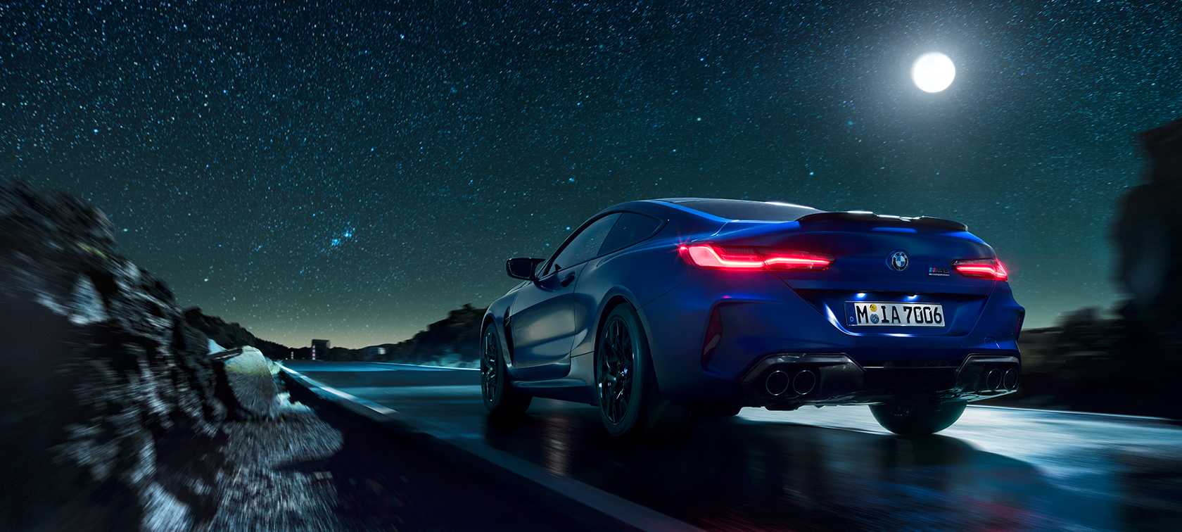 BMW M8 Competition Coupé, rear view F92. BMW M8 Competition Coupé, rear view, driving at night with full moon F92.