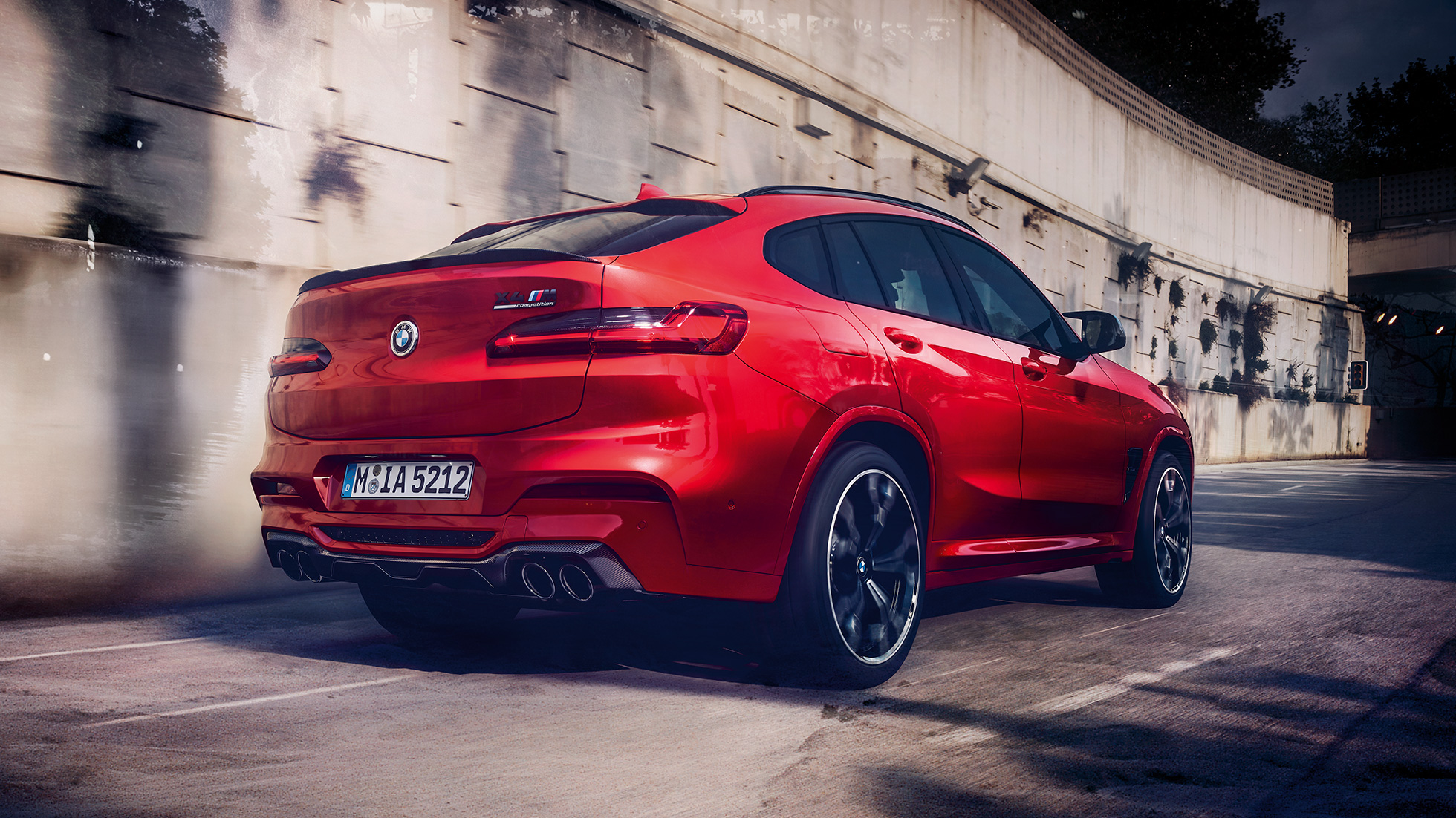 BMW X4 M Competition SUV, lateral rear view F98. BMW X4 M Competition SUV in Toronto Red metallic, exterior, lateral rear view F98.
