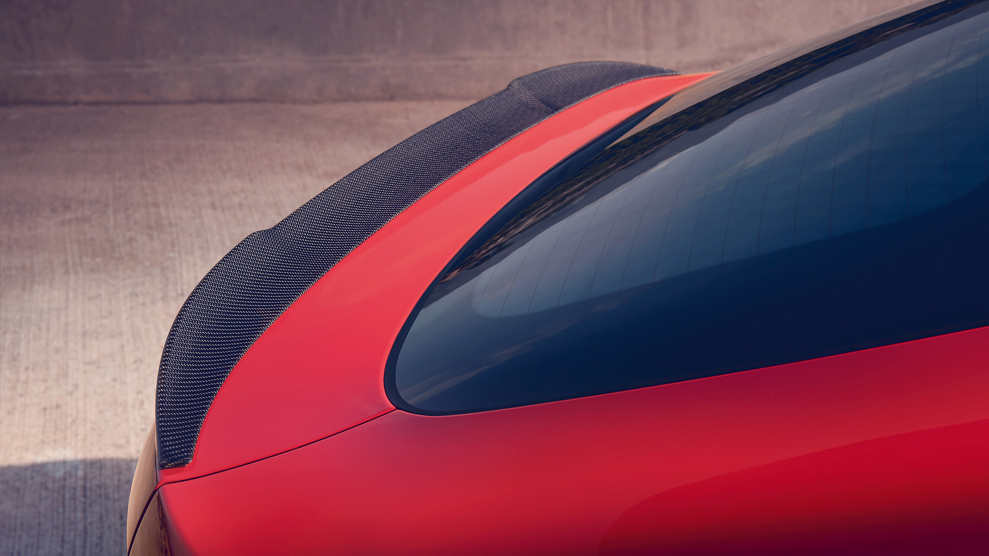 BMW X4 M Competition SUV, M rear spoiler in carbon F98. BMW X4 M Competition SUV in Toronto Red metallic, exterior, M Carbon exterior package, detailed rear view with M rear spoiler in carbon F98.