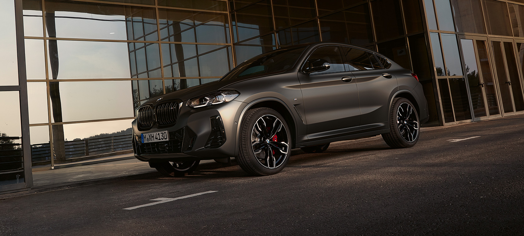 Three-quarter front view BMW X4 M40i G02 LCI 2021 Facelift BMW X4 M40i G02 LCI 2021 Facelift three-quarter front view in front of glass facade