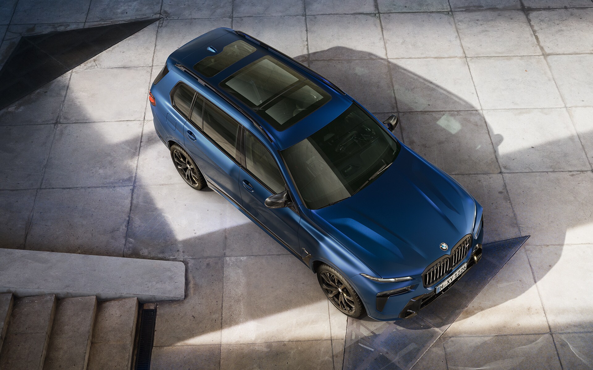 BMW X7 M60i xDrive G07 LCI Frozen Marina Bay Blue rear view driving BMW X7 M60i xDrive G07 LCI Frozen Marina Bay Blue rear view driving