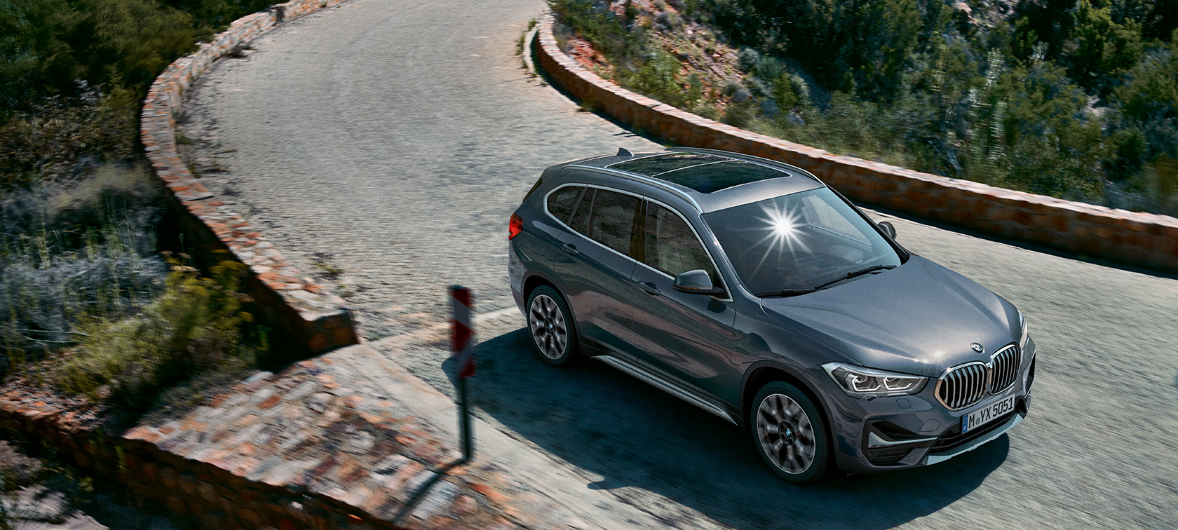 BMW X1, Model xLine (F48), Gray SUV, three quarter front view, driving BMW X1 xLine (F48) Gray SUV three quarter front view driving on the street