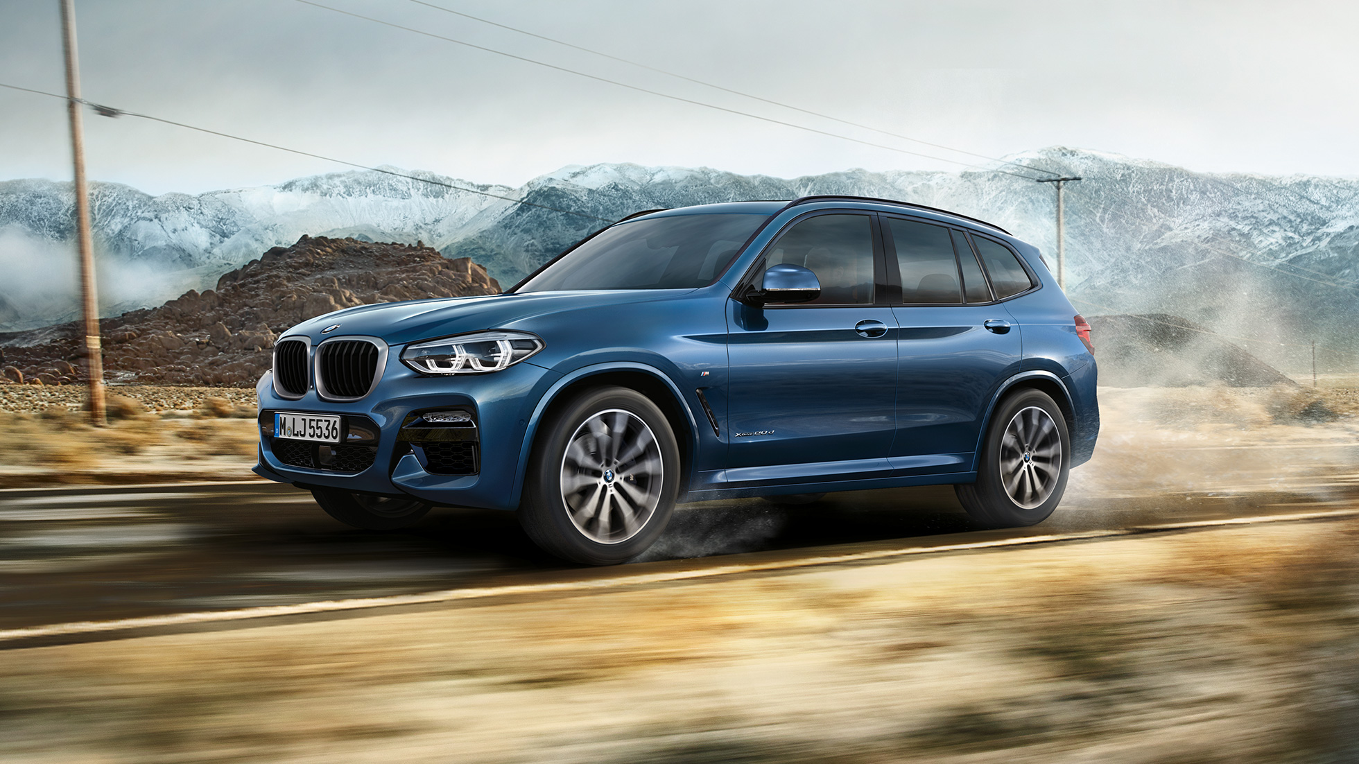 BMW X3 M40i 2020 G01 side view driving BMW X3 M40i 2020 G01 in front of mountains side view driving