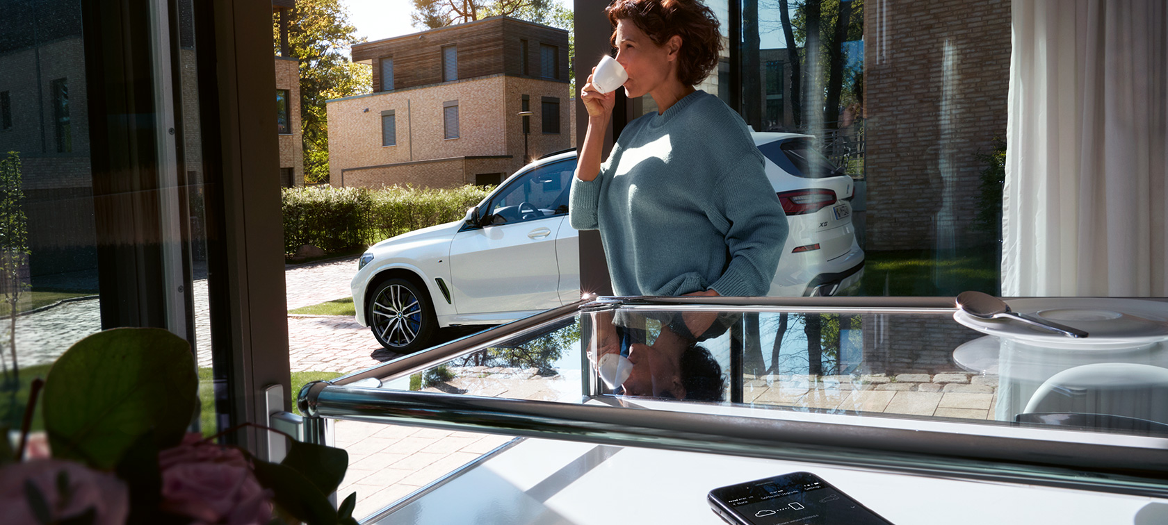 BMW Remote Software Upgrade Woman drinking from cup while BMW Remote Software Upgrade updates the software of her BMW X5