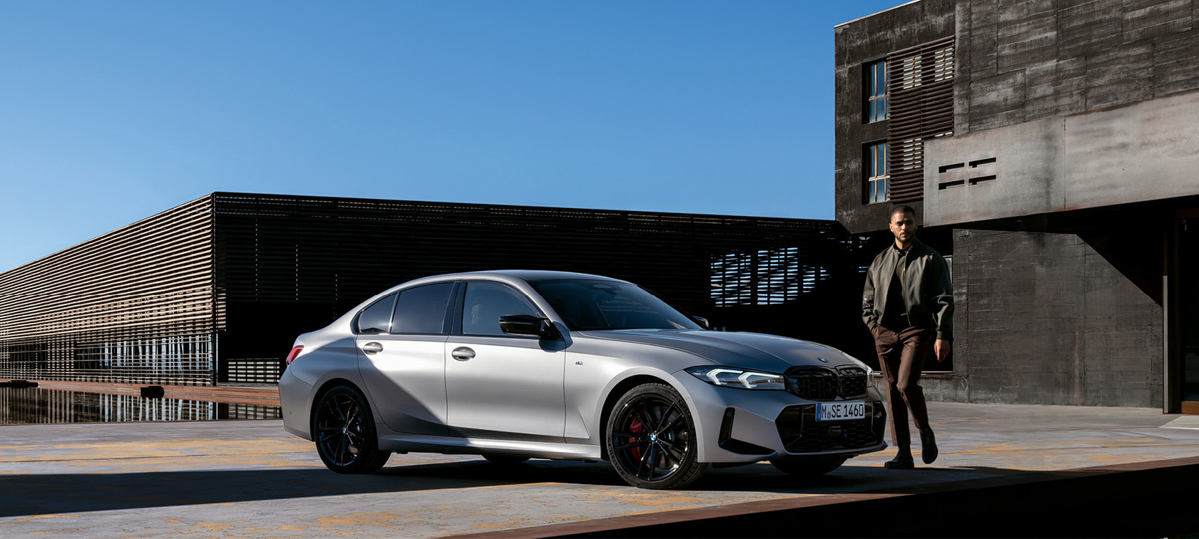BMW 3 Series Sedan LCI G20 Brookly Grey side view standing in front of wall