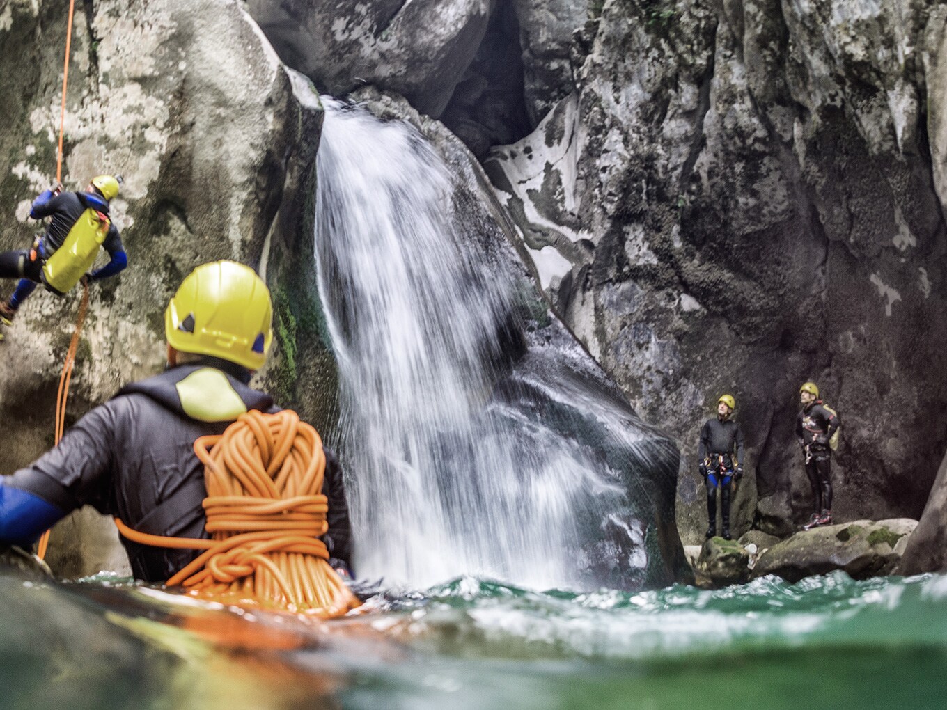 Tour di canyoning ai piedi di una cascata durante il canyoning in Algovia, in un bacino dove l’acqua arriva all’altezza dei fianchi