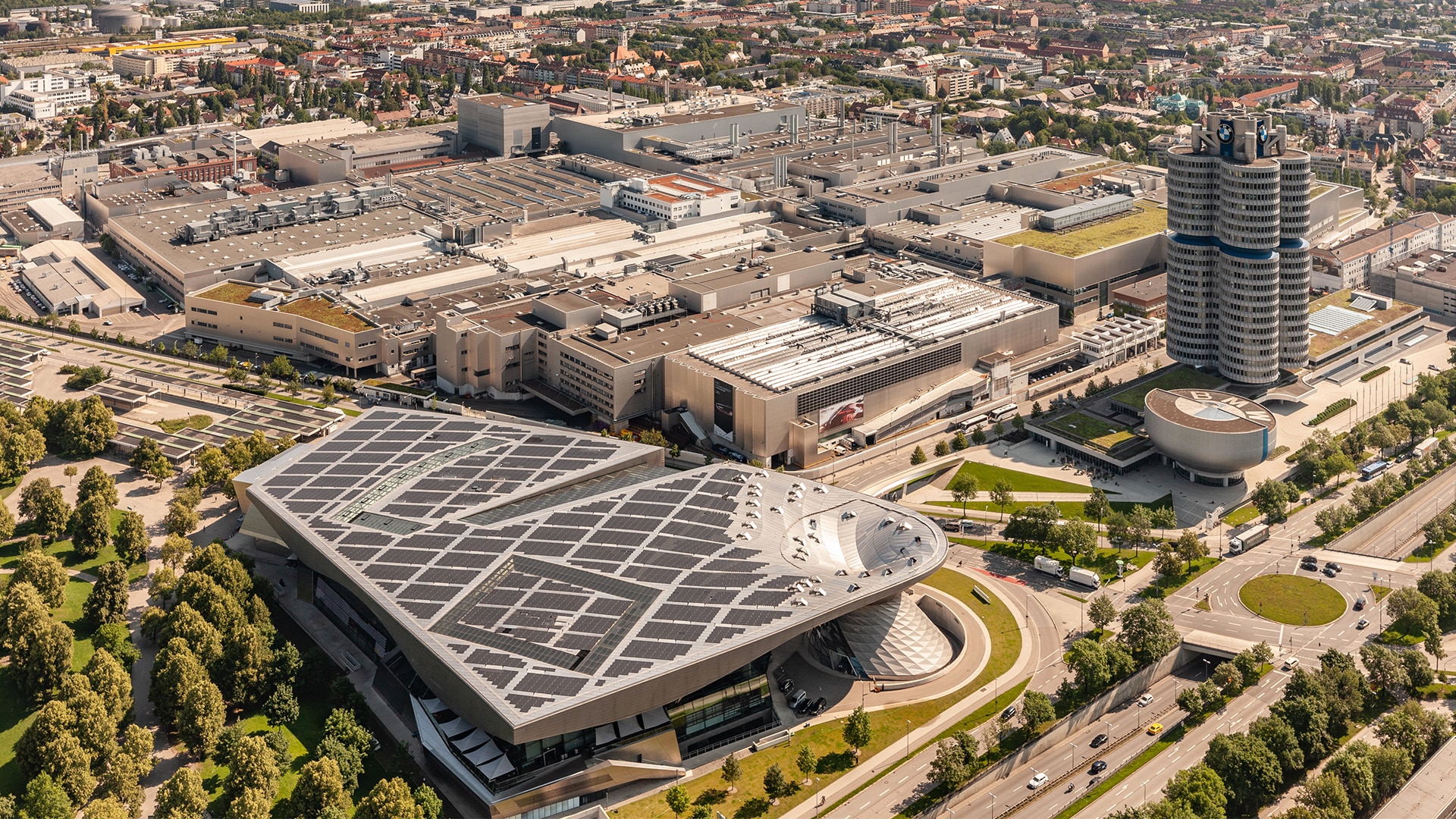 The Milbertshofen site is now the headquarters of BMW AG, with its famous four-cylinder tower and the BMW Welt (front left).