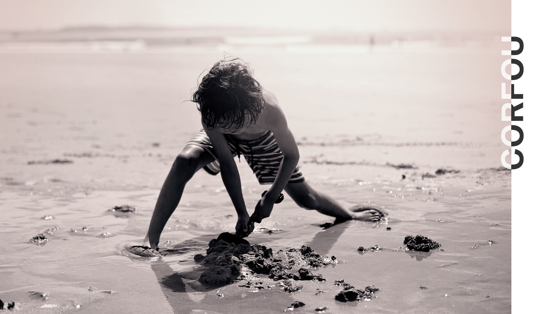 Corfou, un enfant creuse dans le sable