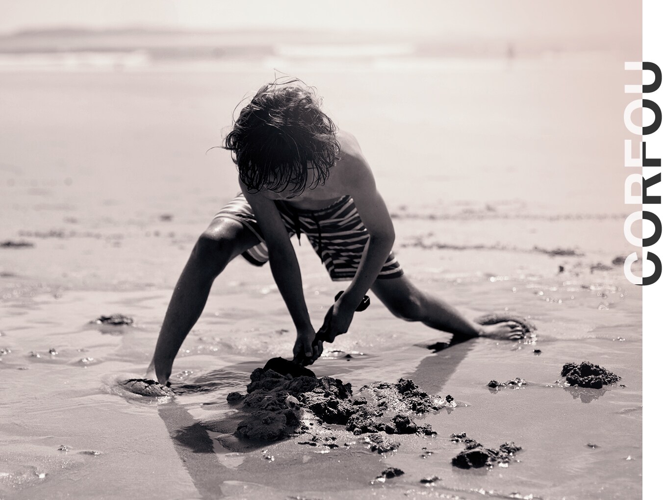 Corfou, un enfant creuse dans le sable