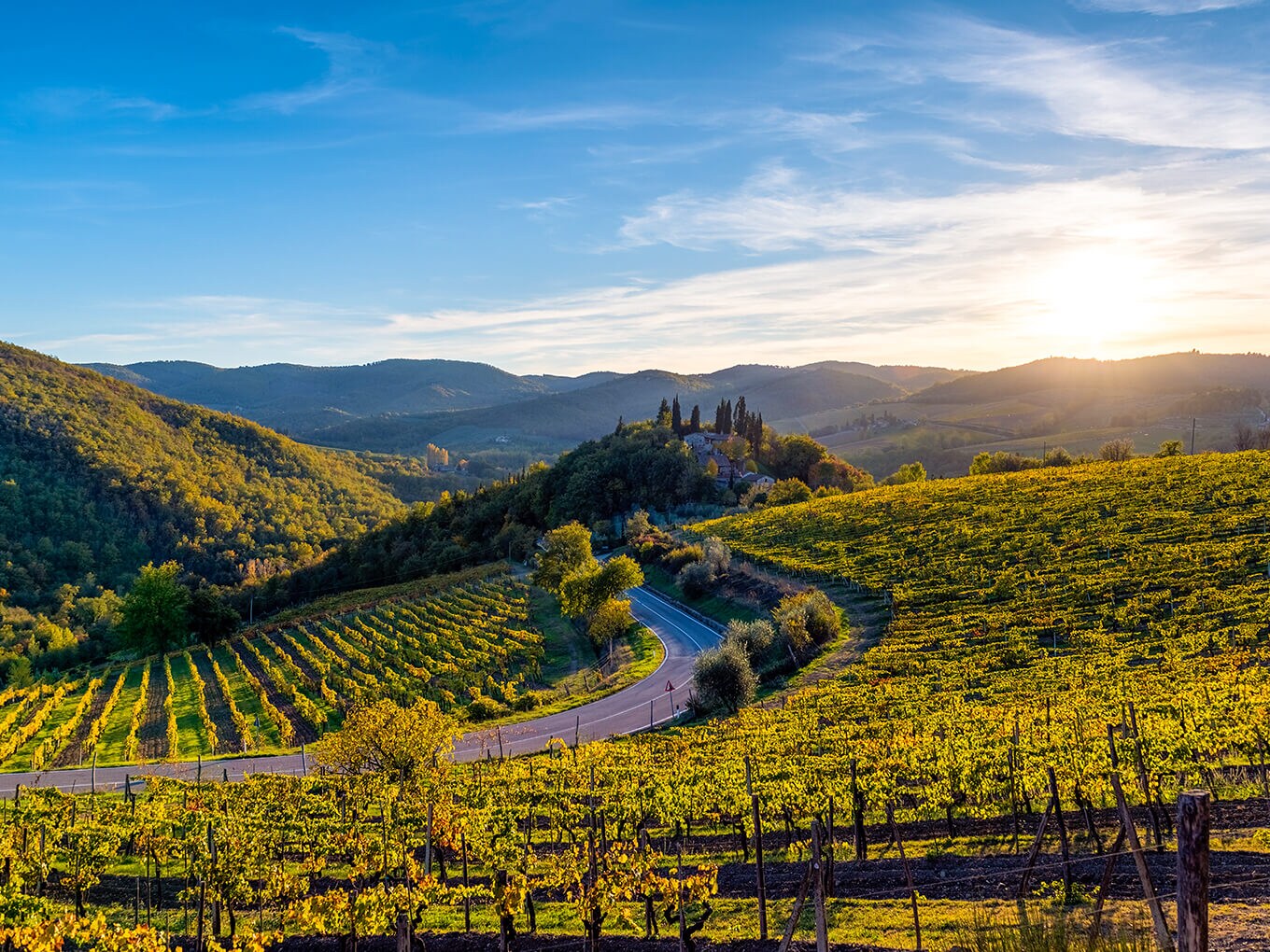 Una sinuosa stradina di campagna conduce attraverso un paesaggio montuoso: glamping in Europa