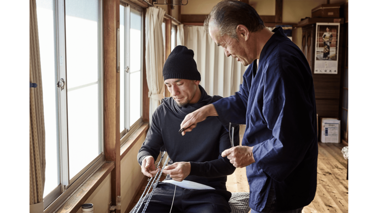 結城紬の絣くくり(柄をつくる作業)を担当する森肇さんに作業を教わる。