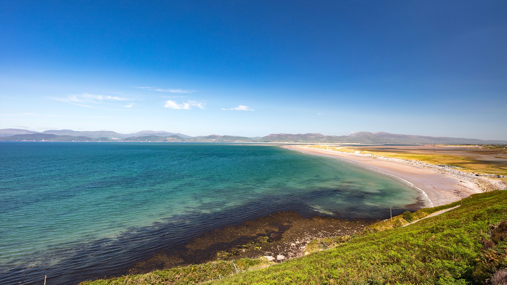 Ruta por Irlanda: el Ring of Kerry (Anillo de Kerry). En la ruta panorámica más famosa, en torno a la península de Iveragh en la zona suroeste del país, atravesarás algunos de los mejores paisajes que ver en Irlanda: islas abruptas, playas desiertas y hermosos puertos de montaña. A lo largo de esta carretera de 170 km, verás lugares como las playas de arena blanca de Rossbeigh y Derrynane, los lagos cerca de Killarney o el paso de montaña de Moll’s Gap. En teoría, se puede hacer todo el itinerario del Anillo de Kerry en un solo día, pero recomendamos que te tomes tu tiempo y lo disfrutes tranquilamente.